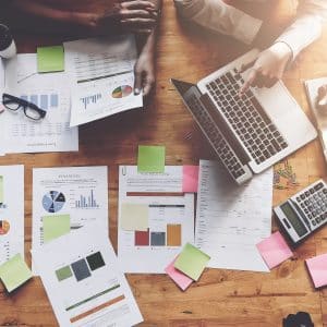 Business People Meeting using laptop computer,calculator,notebook,stock market chart paper for analysis Plans to improve quality next month. Conference Discussion Corporate Concept