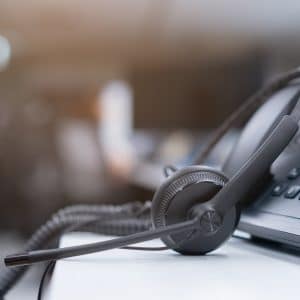 close up black headset with telephone in operation room to communicate with vendor or client for call center and hotline service concept